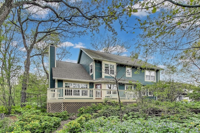 rear view of property with a chimney and a wooden deck