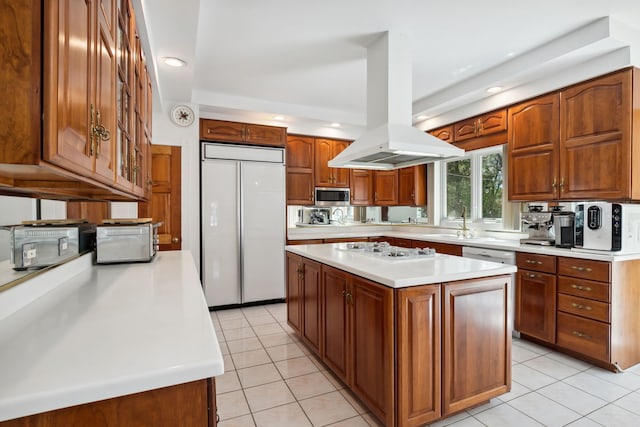 kitchen featuring white appliances, island exhaust hood, light countertops, light tile patterned floors, and brown cabinets