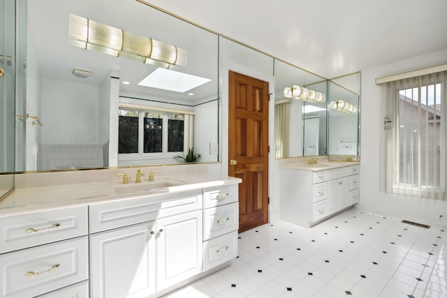 full bathroom with two vanities and a skylight