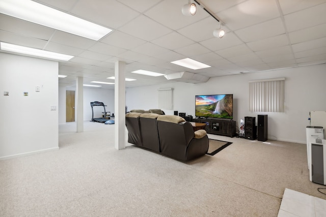 living area with a paneled ceiling, carpet floors, and baseboards