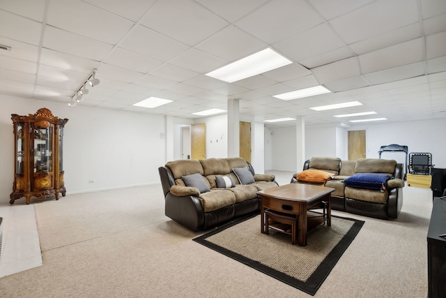 living area featuring carpet flooring and a paneled ceiling