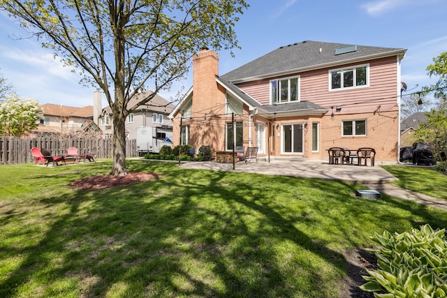 back of house with a patio area, a chimney, brick siding, and roof with shingles
