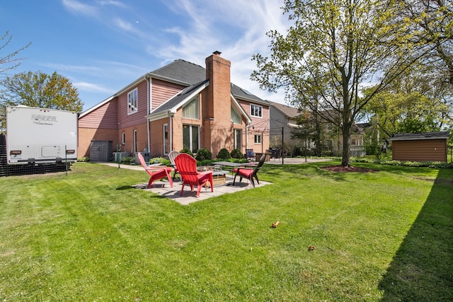 rear view of property with a patio, a chimney, and brick siding