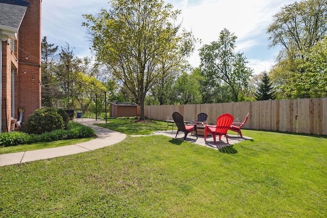 view of yard with a fire pit, a storage unit, an outbuilding, and a patio area
