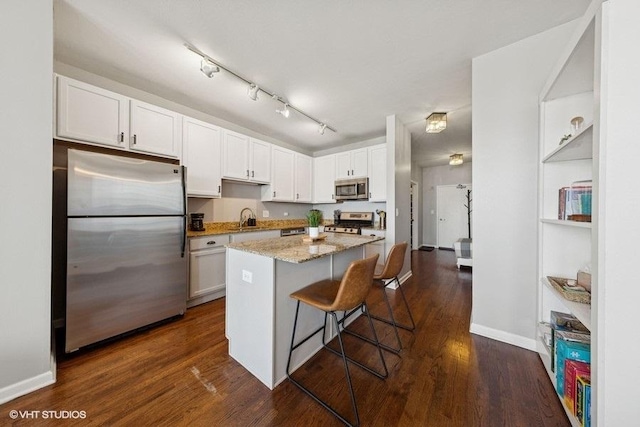 1717 S Prairie Ave Unit 1902, Chicago, IL 60616 - kitchen featuring stainless steel appliances, a sink, white cabinetry, a kitchen bar, and light stone countertops