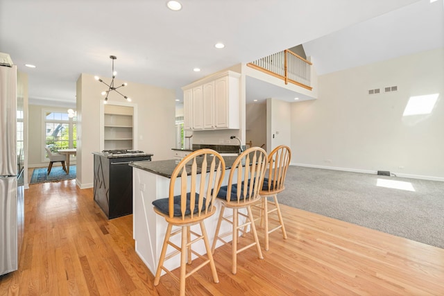 165 Clover Hill Ln, Barrington, IL 60010 - kitchen with baseboards, a chandelier, appliances with stainless steel finishes, light wood-style flooring, and a peninsula