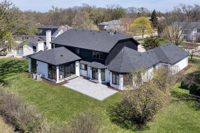 2128 Scotch Pine Ln, Northbrook, IL 60062 - back of property with roof with shingles, a sunroom, a patio area, a lawn, and a residential view