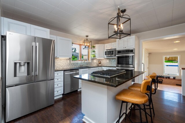 2112 Church St, Johnsburg, IL 60051 - kitchen featuring appliances with stainless steel finishes, a chandelier, a sink, dark wood-style flooring, and a wainscoted wall