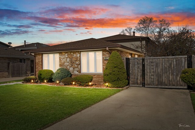 8327 S 78th Ave, Bridgeview, IL 60455 - property exterior at dusk featuring a gate, driveway, stone siding, brick siding, and a chimney