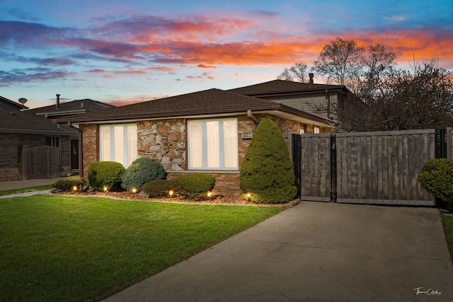 8327 S 78th Ave, Bridgeview, IL 60455 - property exterior at dusk featuring a gate, driveway, stone siding, brick siding, and a chimney