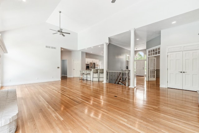 3302 Greenwood Ln, Saint Charles, IL 60175 - unfurnished living room featuring a ceiling fan, a high ceiling, decorative columns, light wood finished floors, and baseboards