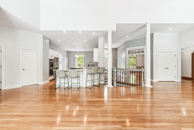 3302 Greenwood Ln, Saint Charles, IL 60175 - kitchen featuring a breakfast bar, white cabinetry, a peninsula, light wood-style flooring, and recessed lighting