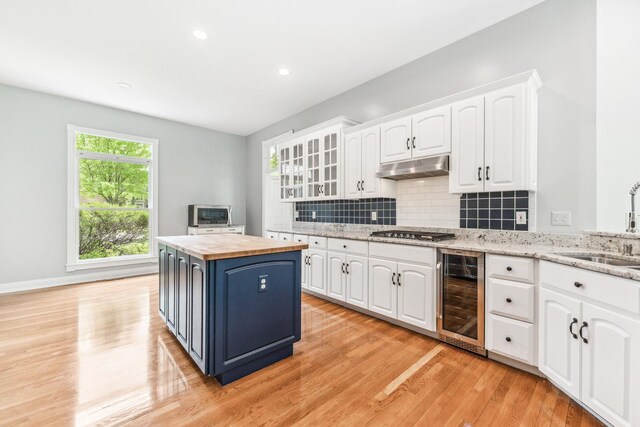 3302 Greenwood Ln, Saint Charles, IL 60175 - kitchen with wine cooler, a sink, butcher block counters, under cabinet range hood, and stainless steel gas cooktop