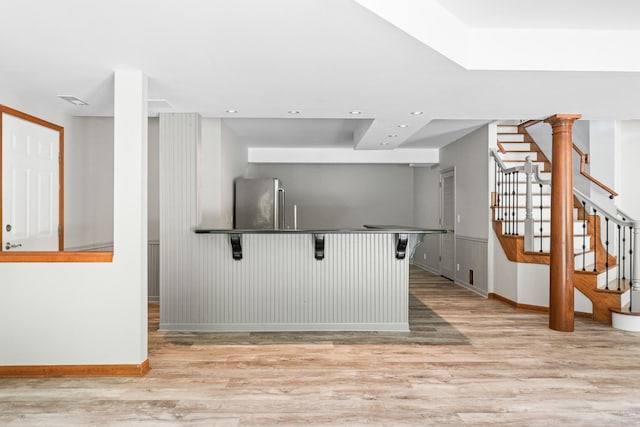 3302 Greenwood Ln, Saint Charles, IL 60175 - kitchen with baseboards, light wood-type flooring, a kitchen breakfast bar, freestanding refrigerator, and dark countertops