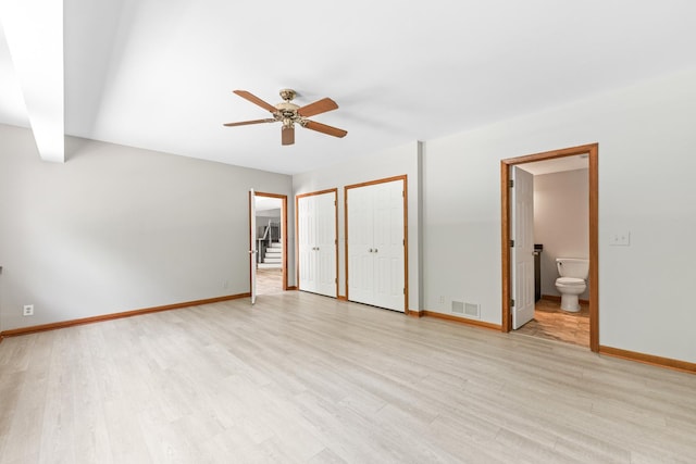3302 Greenwood Ln, Saint Charles, IL 60175 - unfurnished bedroom with multiple closets, baseboards, light wood-type flooring, ensuite bathroom, and a ceiling fan