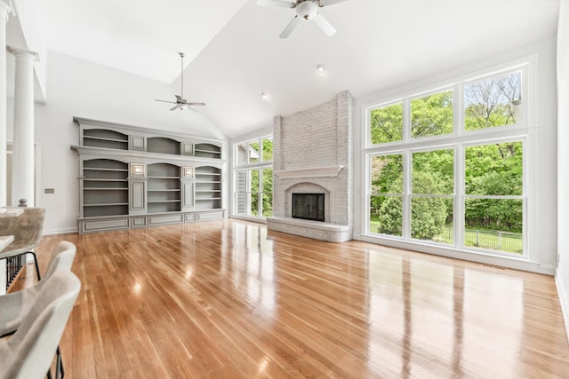 3302 Greenwood Ln, Saint Charles, IL 60175 - unfurnished living room with ceiling fan, a fireplace, wood finished floors, high vaulted ceiling, and ornate columns