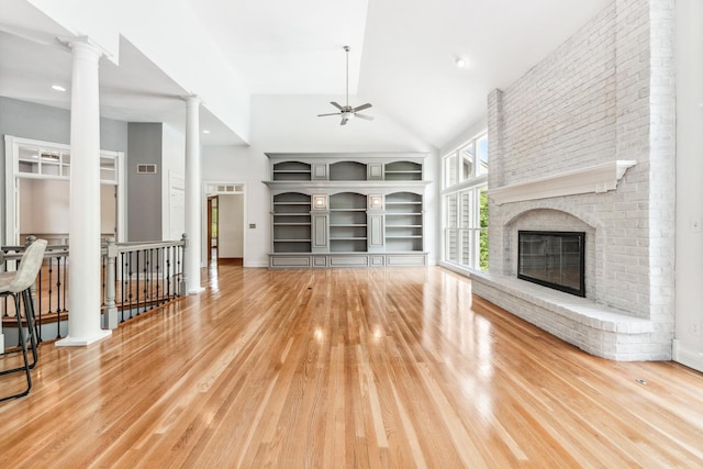 3302 Greenwood Ln, Saint Charles, IL 60175 - unfurnished living room featuring ornate columns, high vaulted ceiling, ceiling fan, a brick fireplace, and wood finished floors