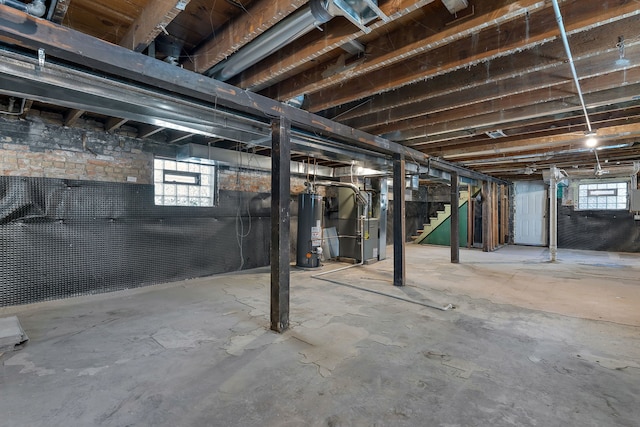 7709 S Eberhart Ave, Chicago, IL 60619 - below grade area featuring gas water heater, heating unit, and stairs