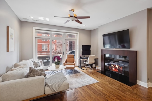 1242 W Jackson Blvd Unit 2W, Chicago, IL 60607 - living area with a ceiling fan, wood finished floors, an office area, a fireplace with flush hearth, and baseboards