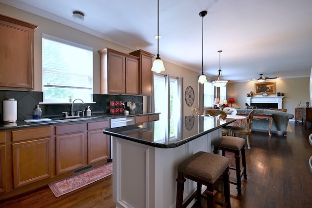 13464 Skyline Dr, Plainfield, IL 60585 - kitchen featuring a breakfast bar, a sink, dark countertops, dark wood finished floors, and ornamental molding