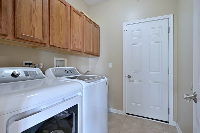 13464 Skyline Dr, Plainfield, IL 60585 - laundry room featuring washer and clothes dryer, light tile patterned floors, cabinet space, and baseboards