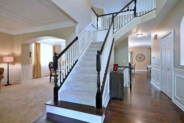 13464 Skyline Dr, Plainfield, IL 60585 - staircase with a decorative wall, arched walkways, crown molding, and a wainscoted wall