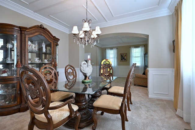 13464 Skyline Dr, Plainfield, IL 60585 - dining space with arched walkways, a chandelier, ornamental molding, light carpet, and a wainscoted wall