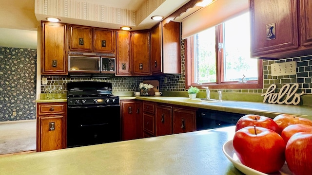 1305 Baugh Dr, Normal, IL 61761 - kitchen featuring black appliances, light countertops, decorative backsplash, wallpapered walls, and a sink