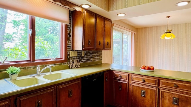1305 Baugh Dr, Normal, IL 61761 - kitchen with dishwasher, a sink, light countertops, wallpapered walls, and hanging light fixtures