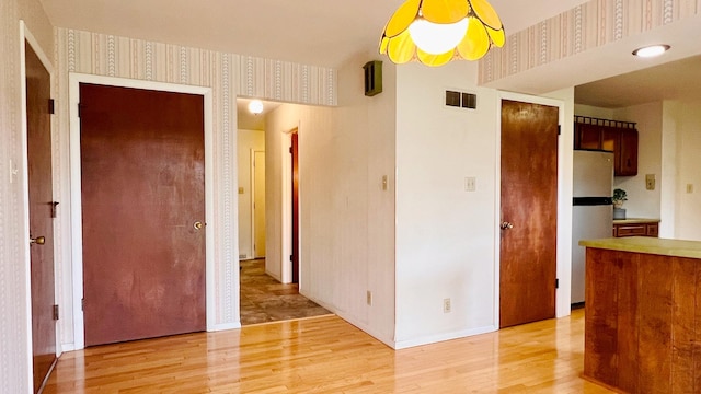 1305 Baugh Dr, Normal, IL 61761 - hallway with wallpapered walls, light wood finished floors, and baseboards