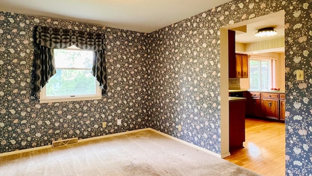 1305 Baugh Dr, Normal, IL 61761 - empty room featuring wood finished floors, baseboards, and wallpapered walls