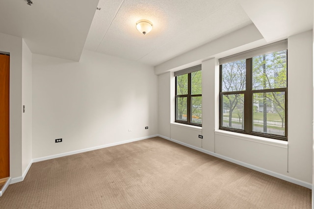 spare room with light carpet and baseboards