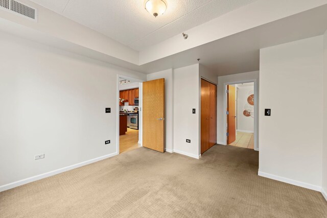 unfurnished bedroom with light colored carpet and baseboards
