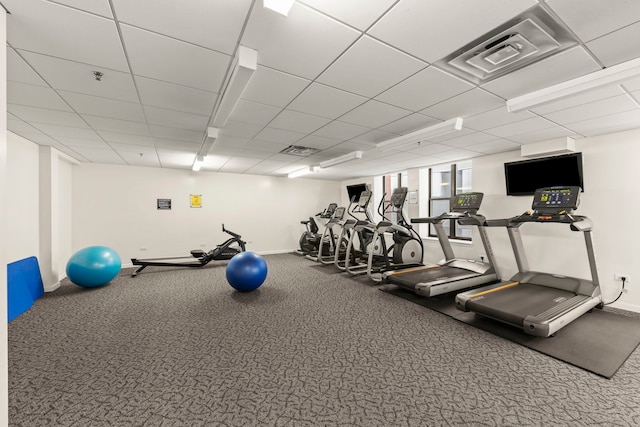 workout area with baseboards and a paneled ceiling