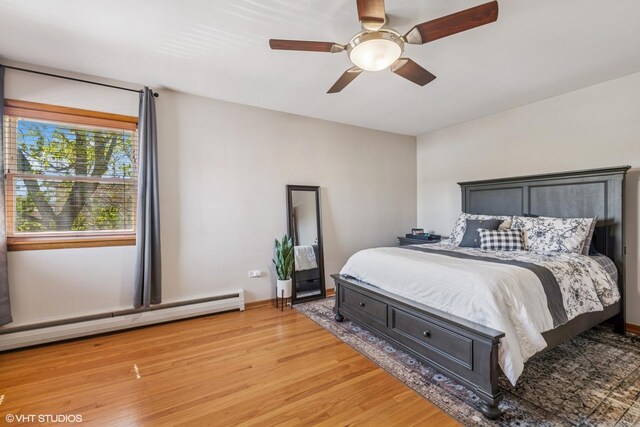 6810 N Ozark Ave Unit 9, Chicago, IL 60631 - bedroom featuring a baseboard heating unit, light wood-style flooring, and a ceiling fan