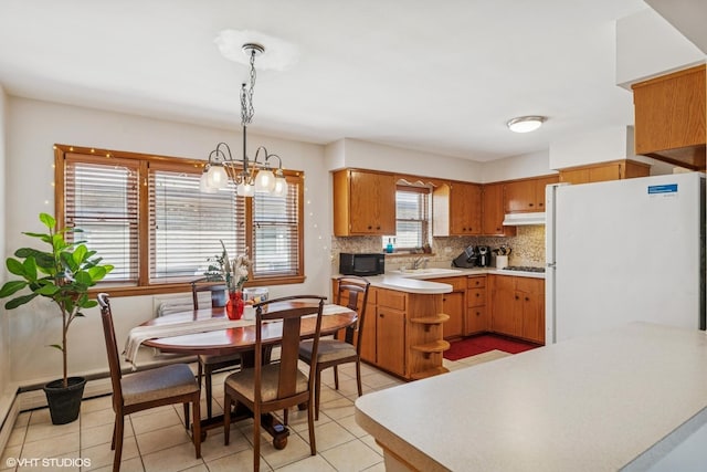 6810 N Ozark Ave Unit 9, Chicago, IL 60631 - kitchen with freestanding refrigerator, black microwave, under cabinet range hood, backsplash, and light tile patterned floors