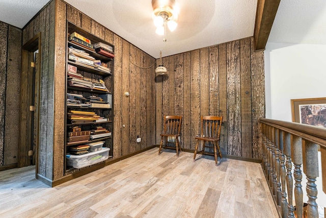 1479 Old Mill Rd, Franklin Grove, IL 61031 - sitting room featuring wood walls, wood finished floors, a textured ceiling, a ceiling fan, and beamed ceiling