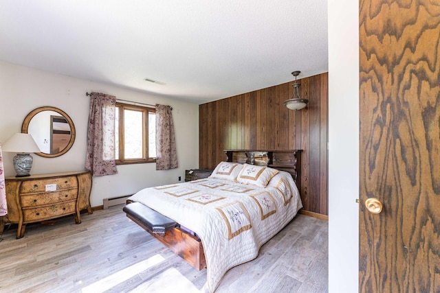 1479 Old Mill Rd, Franklin Grove, IL 61031 - bedroom featuring wooden walls, light wood finished floors, a baseboard radiator, and baseboards