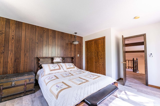 1479 Old Mill Rd, Franklin Grove, IL 61031 - bedroom with wooden walls, light wood-style floors, baseboards, and a closet