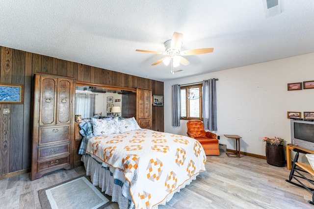 1479 Old Mill Rd, Franklin Grove, IL 61031 - bedroom with wooden walls, light wood-style flooring, baseboards, a baseboard radiator, and ceiling fan