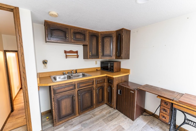 1479 Old Mill Rd, Franklin Grove, IL 61031 - kitchen featuring black microwave, a sink, light wood-style floors, dark brown cabinets, and light countertops