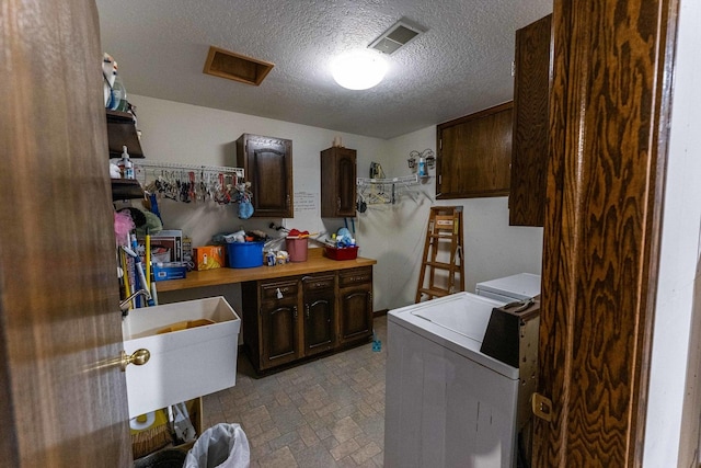 1479 Old Mill Rd, Franklin Grove, IL 61031 - laundry room featuring washing machine and dryer, cabinet space, and a textured ceiling