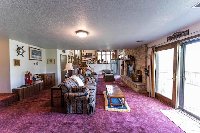 1479 Old Mill Rd, Franklin Grove, IL 61031 - carpeted living room featuring a textured ceiling, a stone fireplace, and stairway