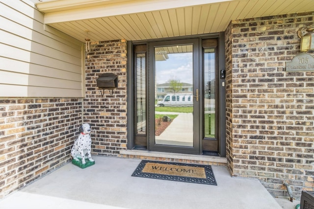 view of exterior entry with brick siding