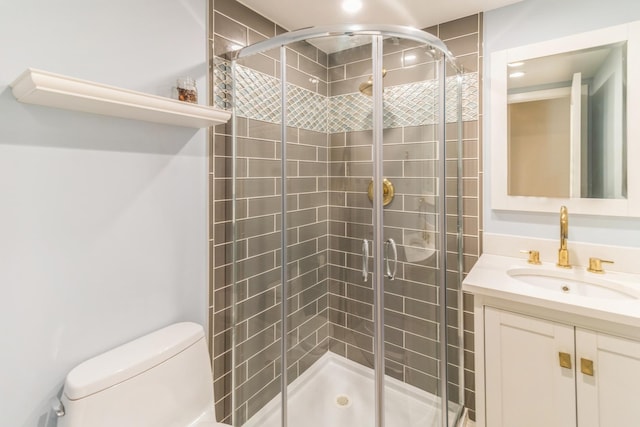 bathroom with a stall shower, toilet, and vanity