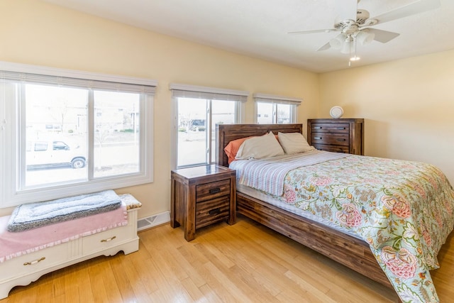 bedroom featuring light wood finished floors, a ceiling fan, and baseboards