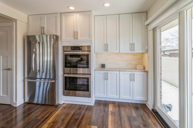 kitchen with appliances with stainless steel finishes, white cabinets, light countertops, dark wood finished floors, and recessed lighting