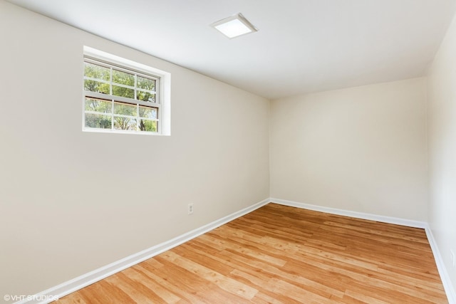unfurnished room with baseboards and light wood-style flooring