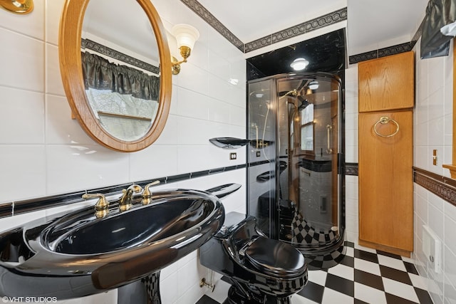 bathroom with tile walls, a stall shower, tile patterned floors, and toilet