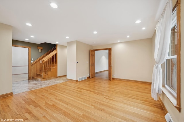 unfurnished living room with light wood-style flooring, stairway, recessed lighting, and baseboards